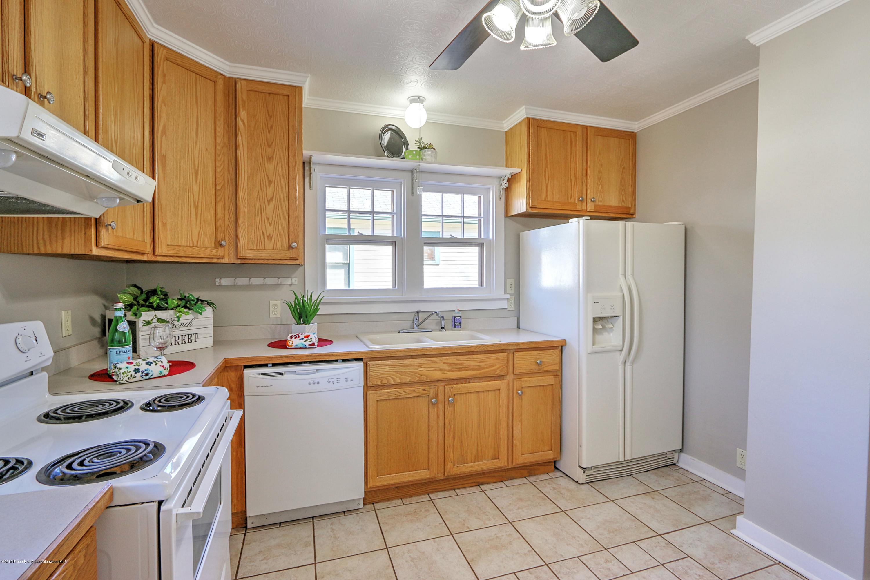 721 East Avenue Rifle, CO 81650 - Photo 11 of 24 a kitchen with stainless steel appliances a stove a sink cabinets and a window