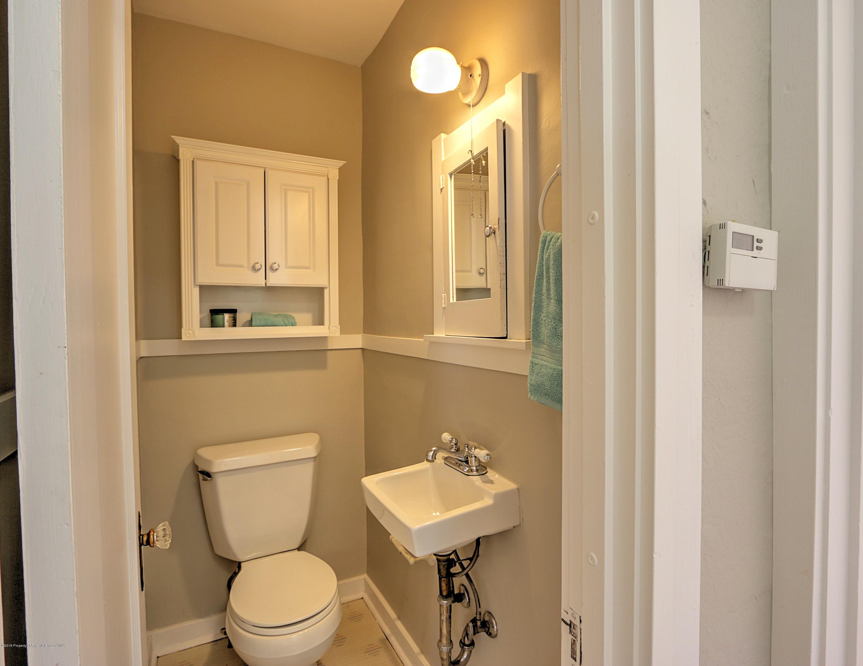 721 East Avenue Rifle, CO 81650 - Photo 12 of 24 a bathroom with a toilet a sink and a mirror