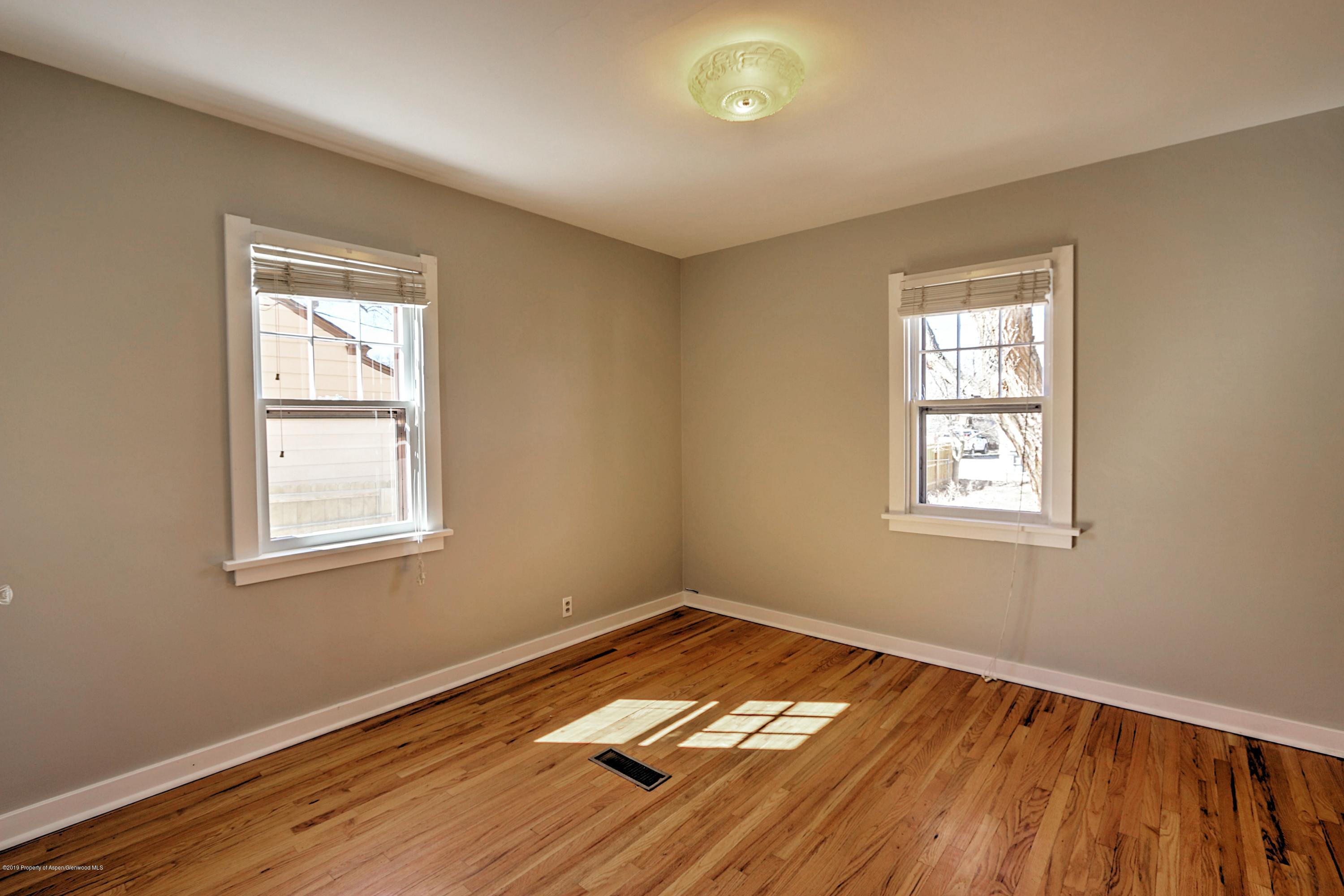 721 East Avenue Rifle, CO 81650 - Photo 14 of 24 an empty room with wooden floor and windows