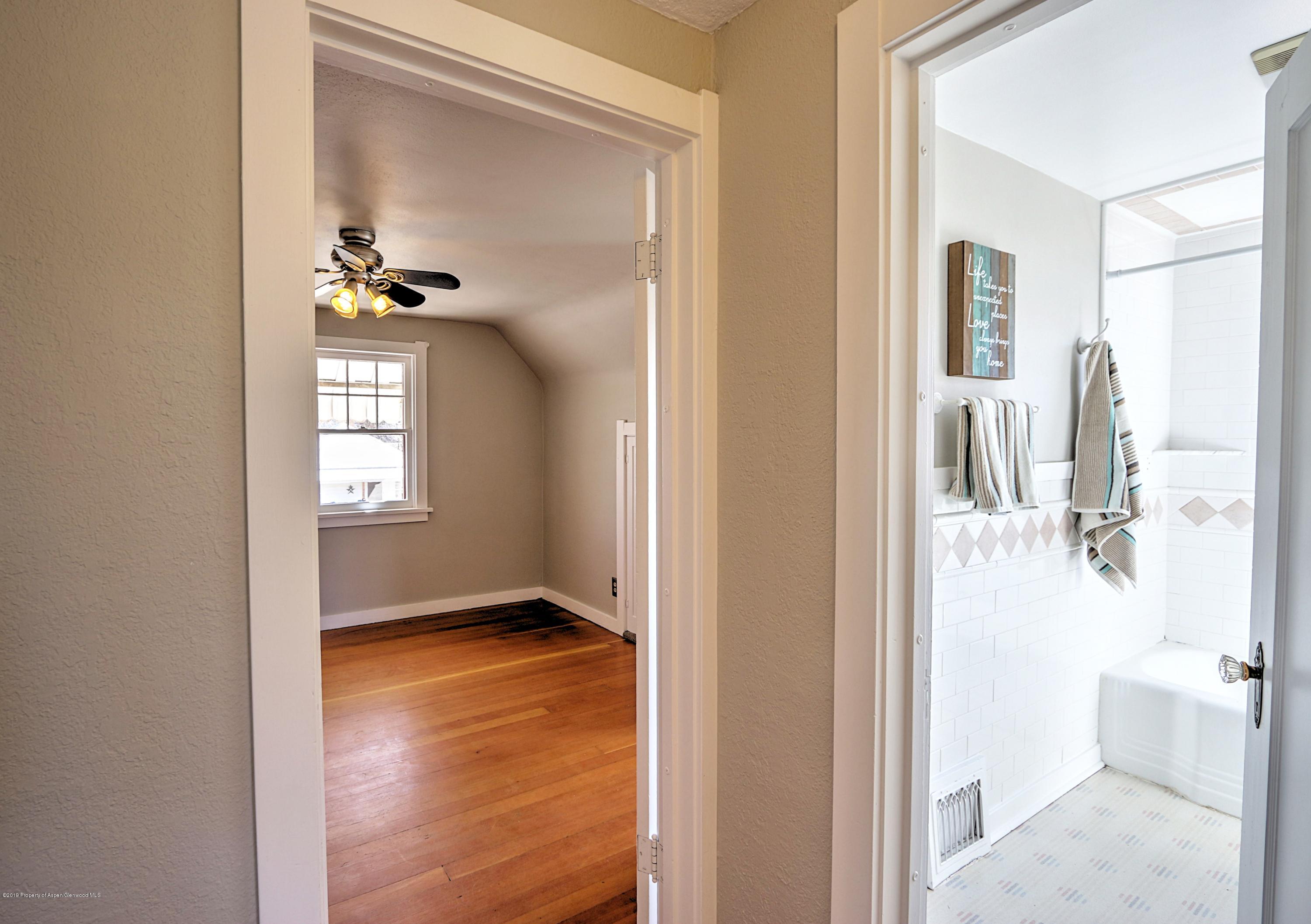721 East Avenue Rifle, CO 81650 - Photo 19 of 24 a view of a hallway with wooden floor and a living room