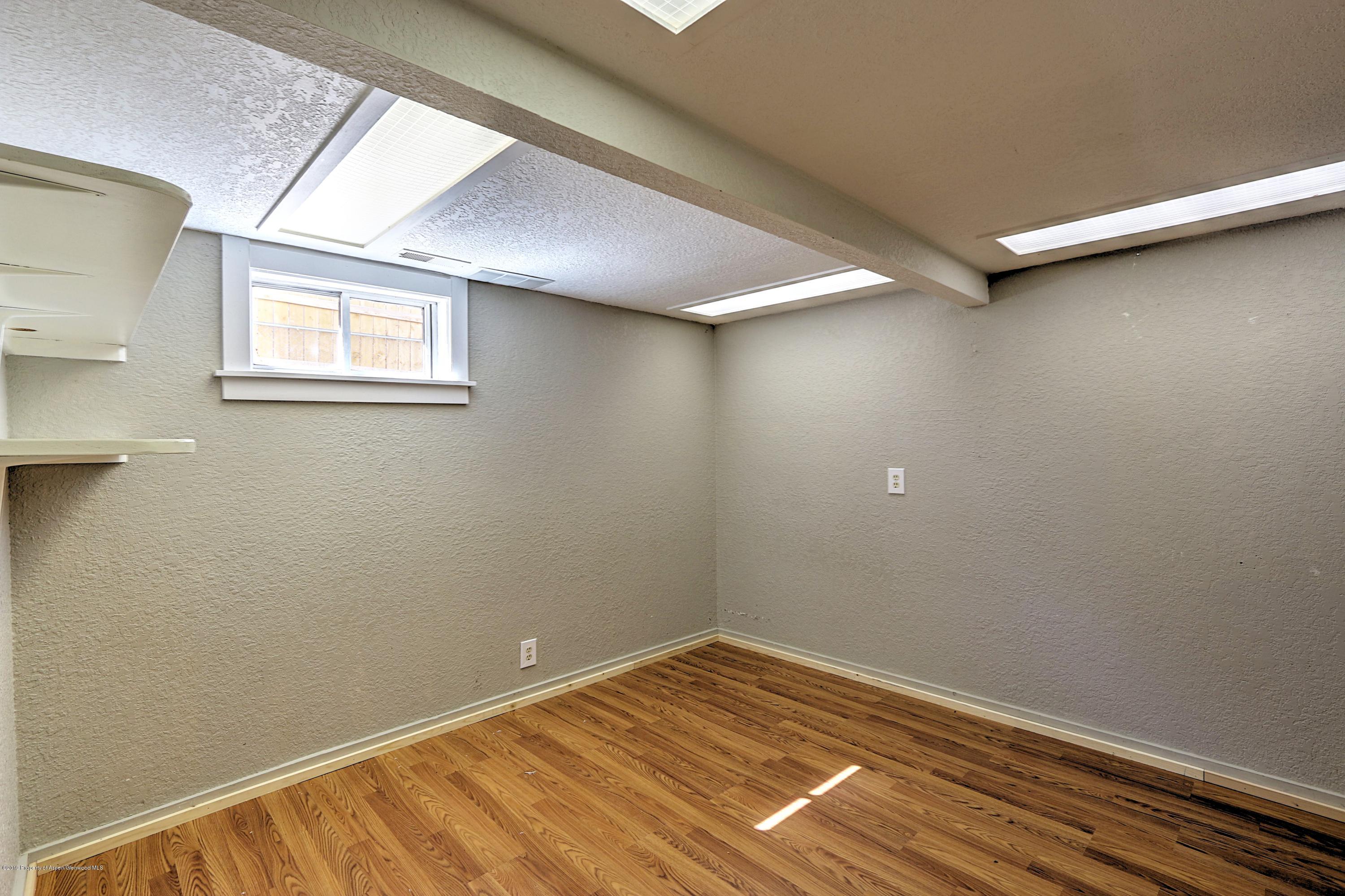 721 East Avenue Rifle, CO 81650 - Photo 23 of 24 an empty room with wooden floor and windows