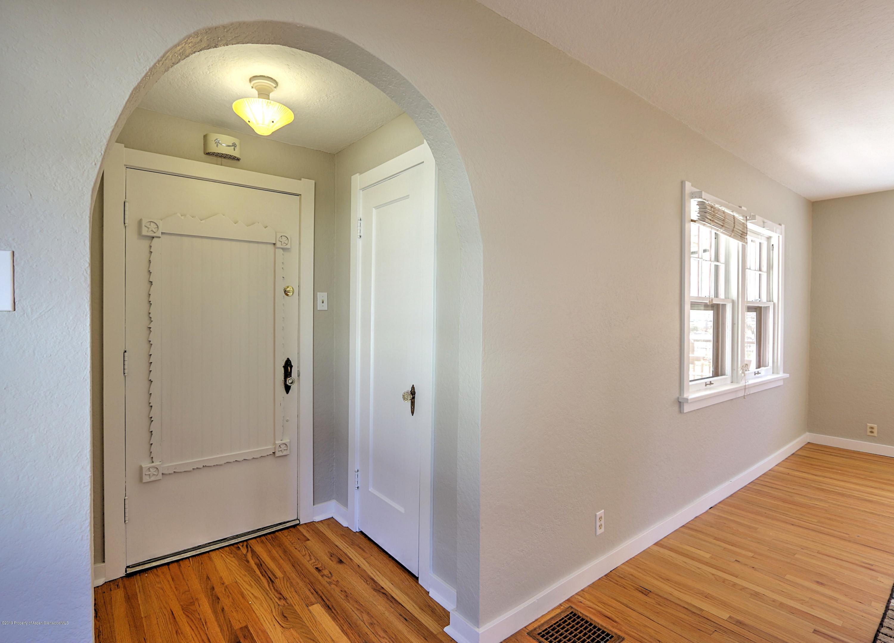 721 East Avenue Rifle, CO 81650 - Photo 4 of 24 an empty room with wooden floor and mirror