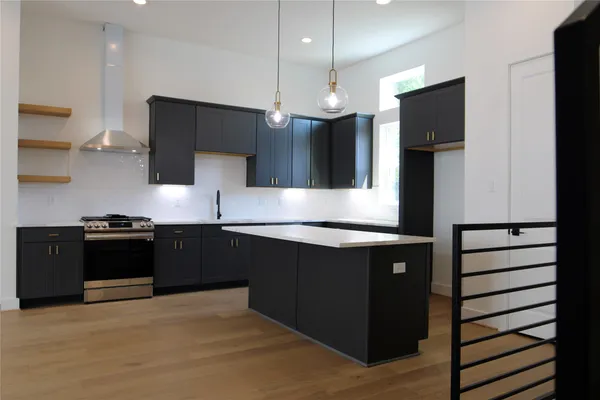 a kitchen with stainless steel appliances granite countertop a refrigerator a sink and a stove