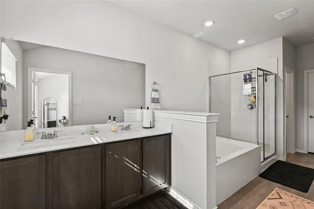 a bathroom with a double vanity sink mirror and bathtub