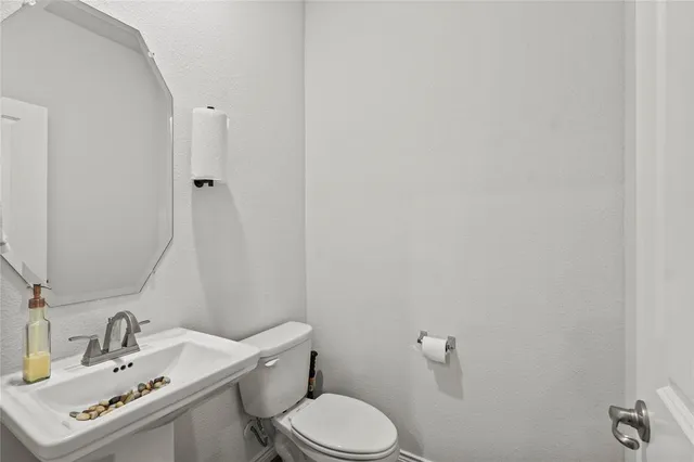 a bathroom with a sink mirror and toilet