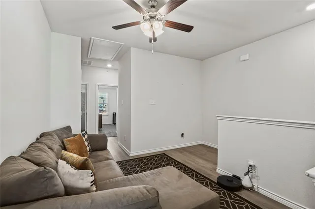 a living room with furniture and a ceiling fan