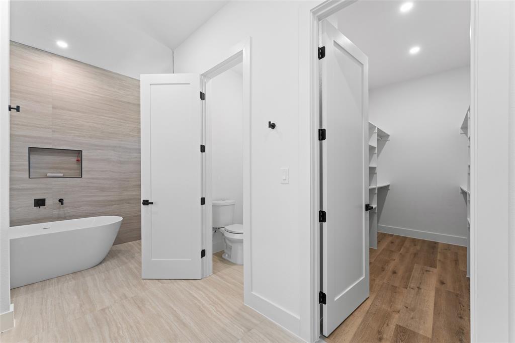 2826 Rochester Street Dallas, TX 75215 - Photo 20 of 38 Bathroom featuring a freestanding bath, recessed lighting, tile walls, a walk in closet, and light wood finished floors