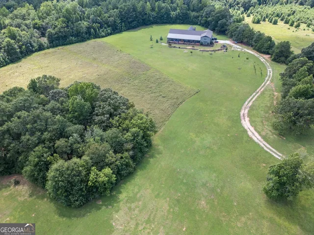 an aerial view of a house with a yard and trees