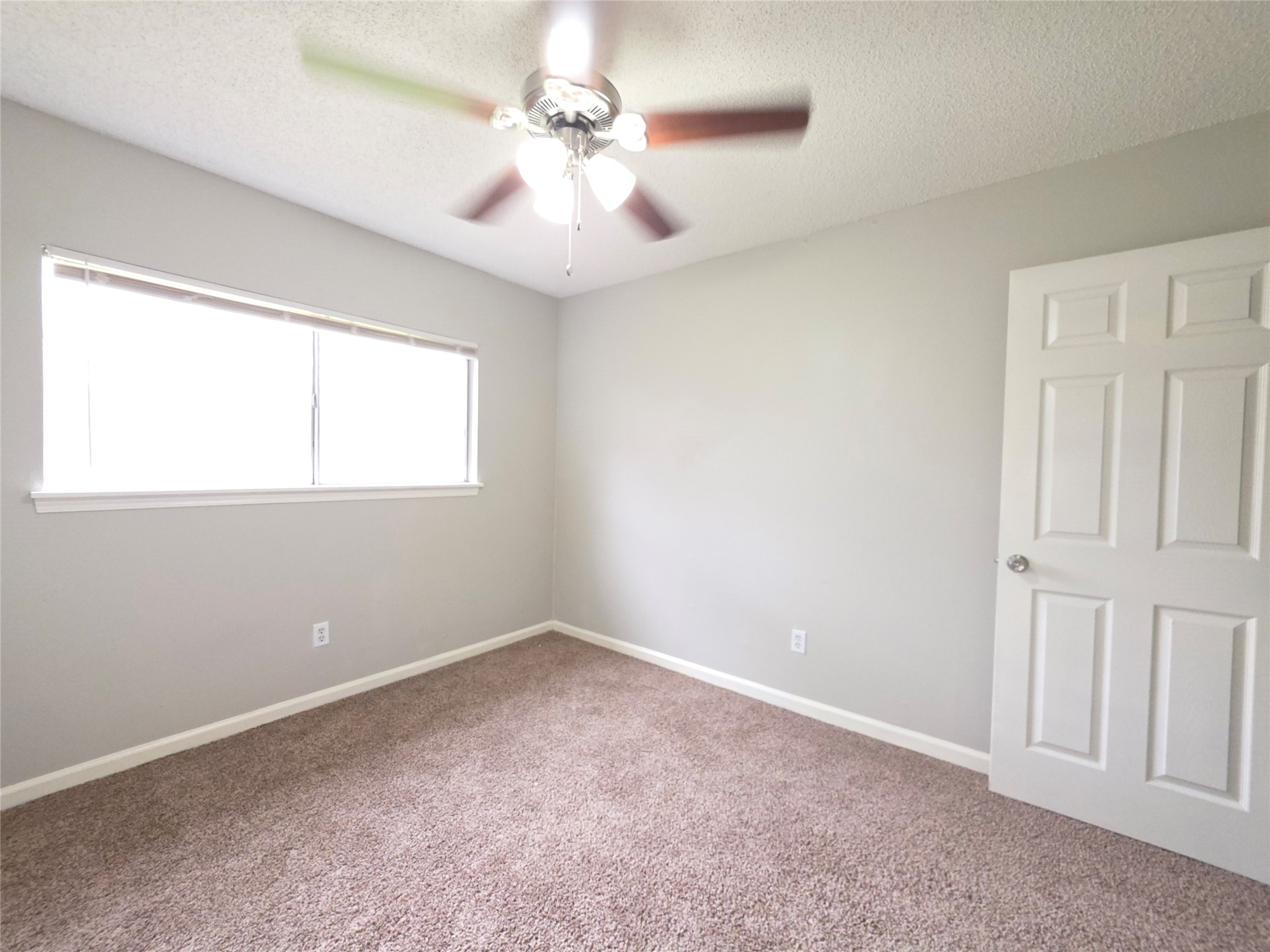 9814 Kiwi Lane Conroe, TX 77385 - Photo 11 of 13 an empty room with windows and fan