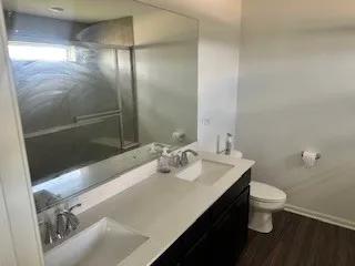a bathroom with a sink a toilet and shower