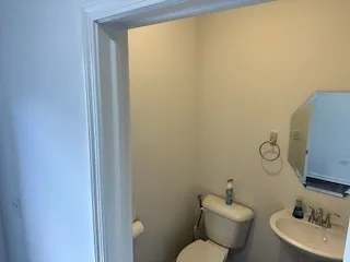 a bathroom with a toilet sink vanity and mirror