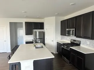 a kitchen with a stove a sink and a refrigerator
