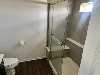 a bathroom with a granite countertop toilet and a shower