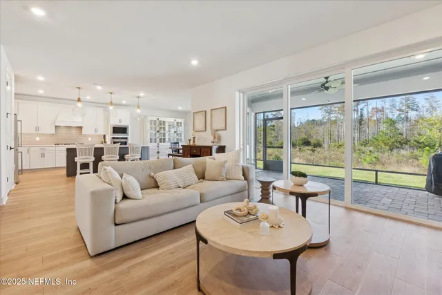 a living room with furniture a rug and kitchen view