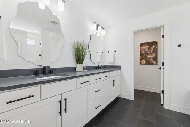a bathroom with double sink and a mirror