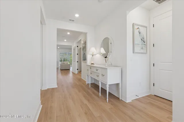 a kitchen with a dining table chairs wooden floor cabinets and appliances