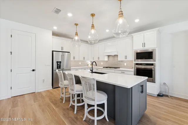 a large kitchen with kitchen island a sink table and chairs