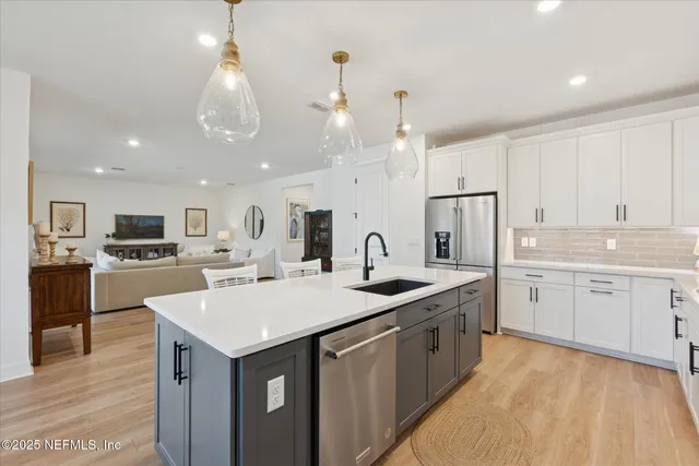 a large kitchen with kitchen island a sink table and chairs