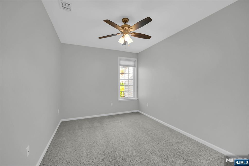 41 Sequoia Drive Cedar Grove, NJ 07009 - Photo 25 of 49 an view of an empty room with window and ceiling fan