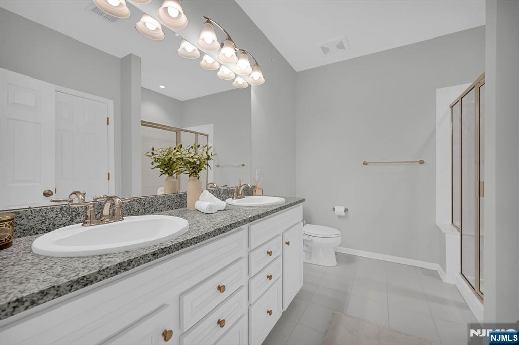 41 Sequoia Drive Cedar Grove, NJ 07009 - Photo 38 of 49 a bathroom with a granite countertop sink a toilet and a mirror