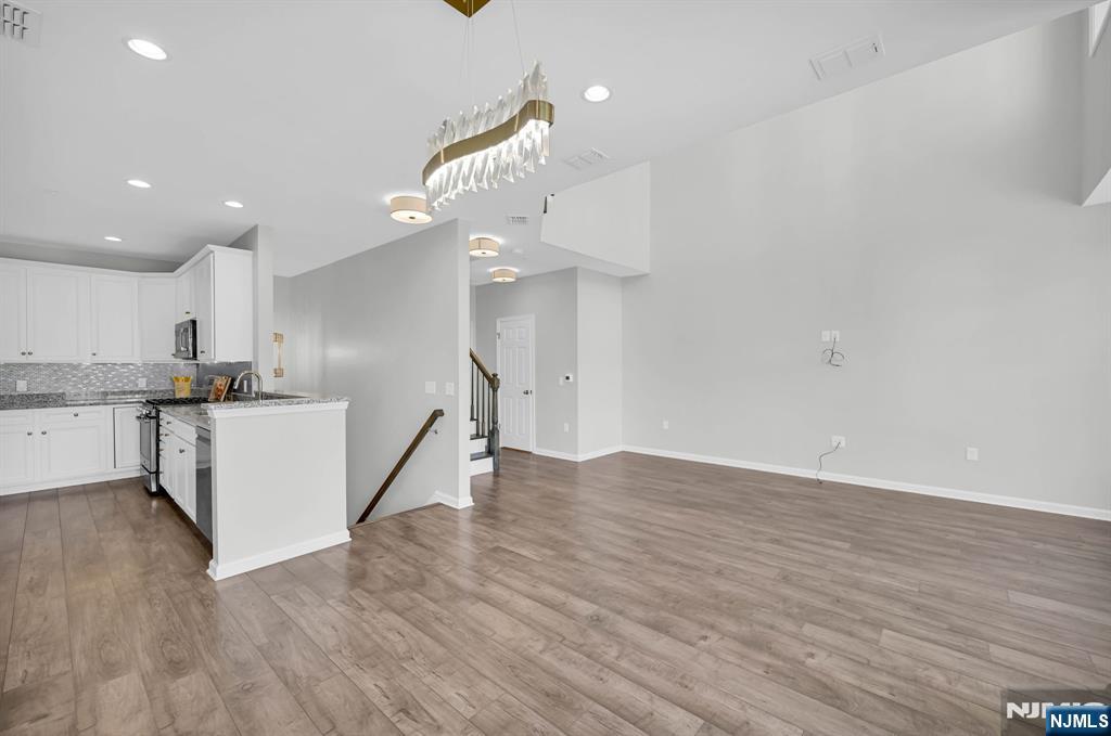 41 Sequoia Drive Cedar Grove, NJ 07009 - Photo 7 of 49 a view of a kitchen with an empty space and wooden floor