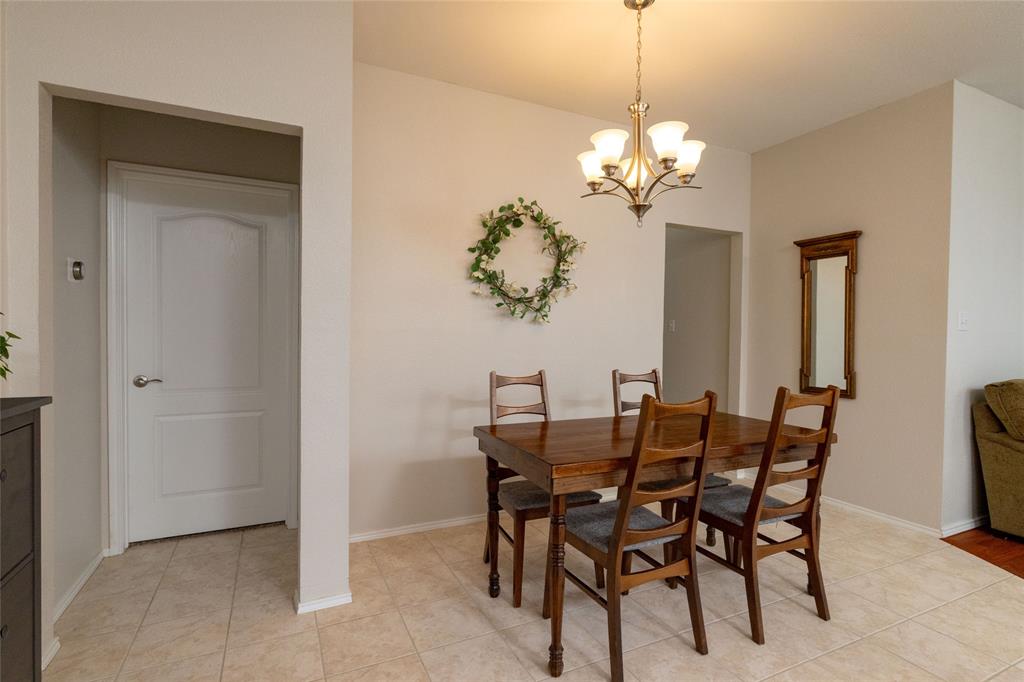 4025 Chisos Rim Trail Fort Worth, TX 76244 - Photo 17 of 40 Dining area featuring a five-light chandelier, neutral wall tones, and square floor tiles