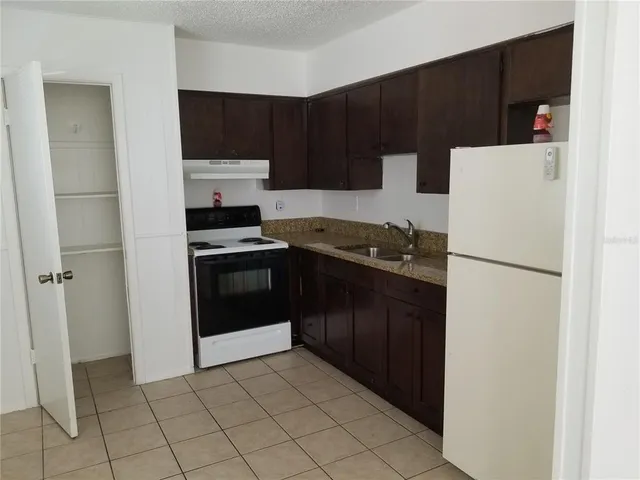 a kitchen with a refrigerator sink and cabinets