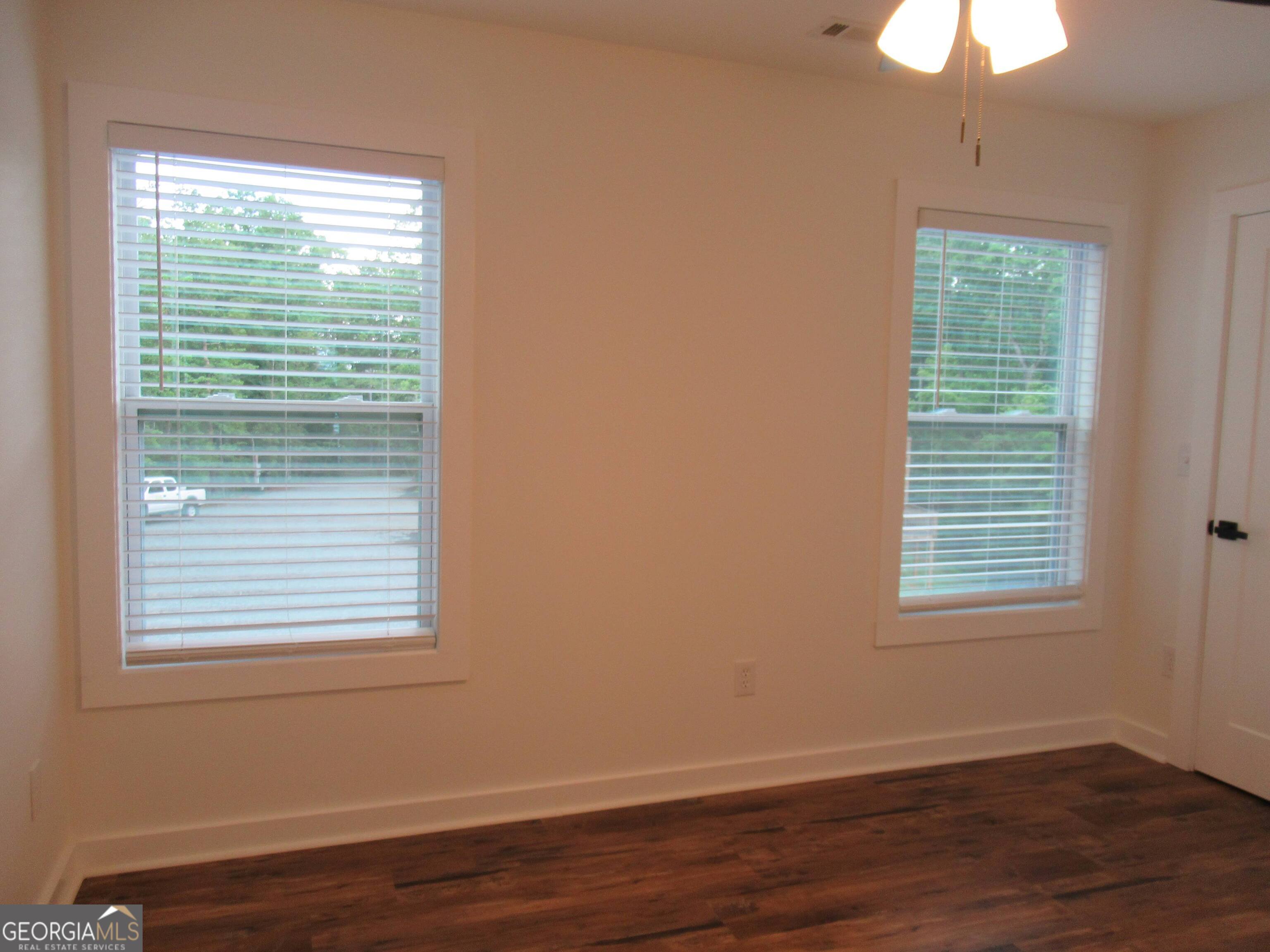 765 Old Kerns Road Dawsonville, GA 30534 - Photo 26 of 36 a view of an empty room with wooden floor and a window