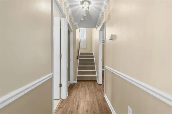 a view of a hallway with wooden floor and staircase
