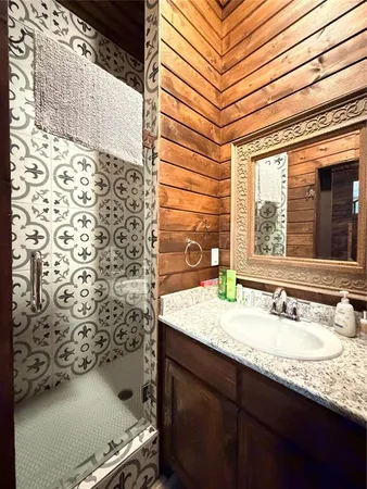 a bathroom with a granite countertop sink toilet and shower