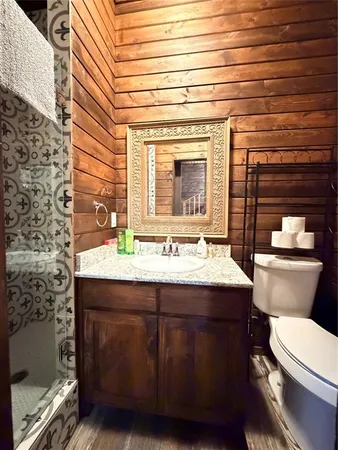 a bathroom with a granite countertop toilet sink and mirror
