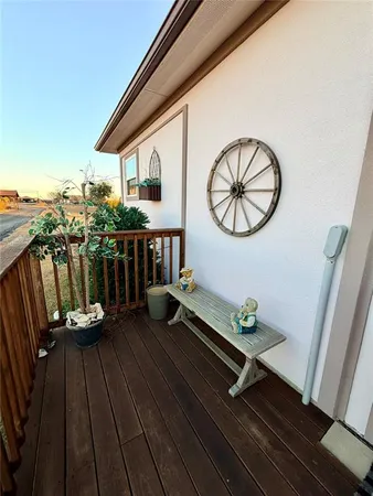 a view of a balcony with chairs and wooden floor