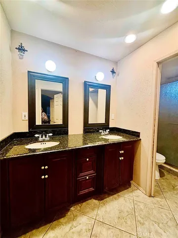 a bathroom with a granite countertop sink vanity and mirror