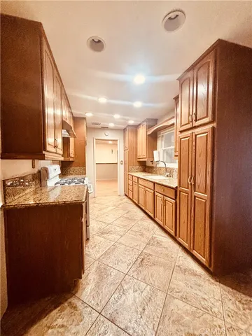 a kitchen with stainless steel appliances granite countertop a refrigerator and a sink
