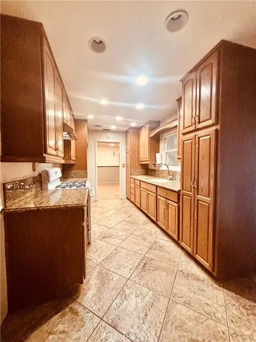 a kitchen with stainless steel appliances granite countertop a refrigerator and a sink