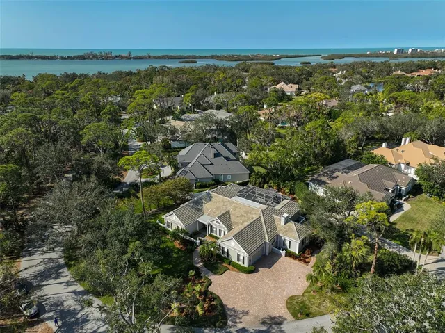 an aerial view of residential house with outdoor space and trees all around