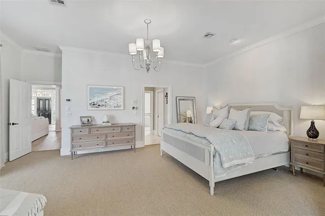 a bedroom with a large bed and a chandelier