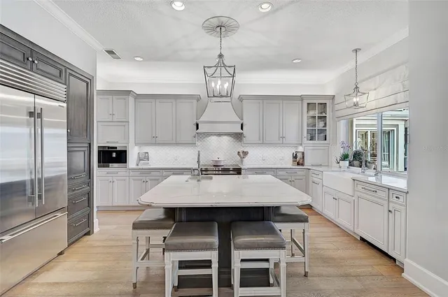 a large kitchen with kitchen island a dining table and stainless steel appliances