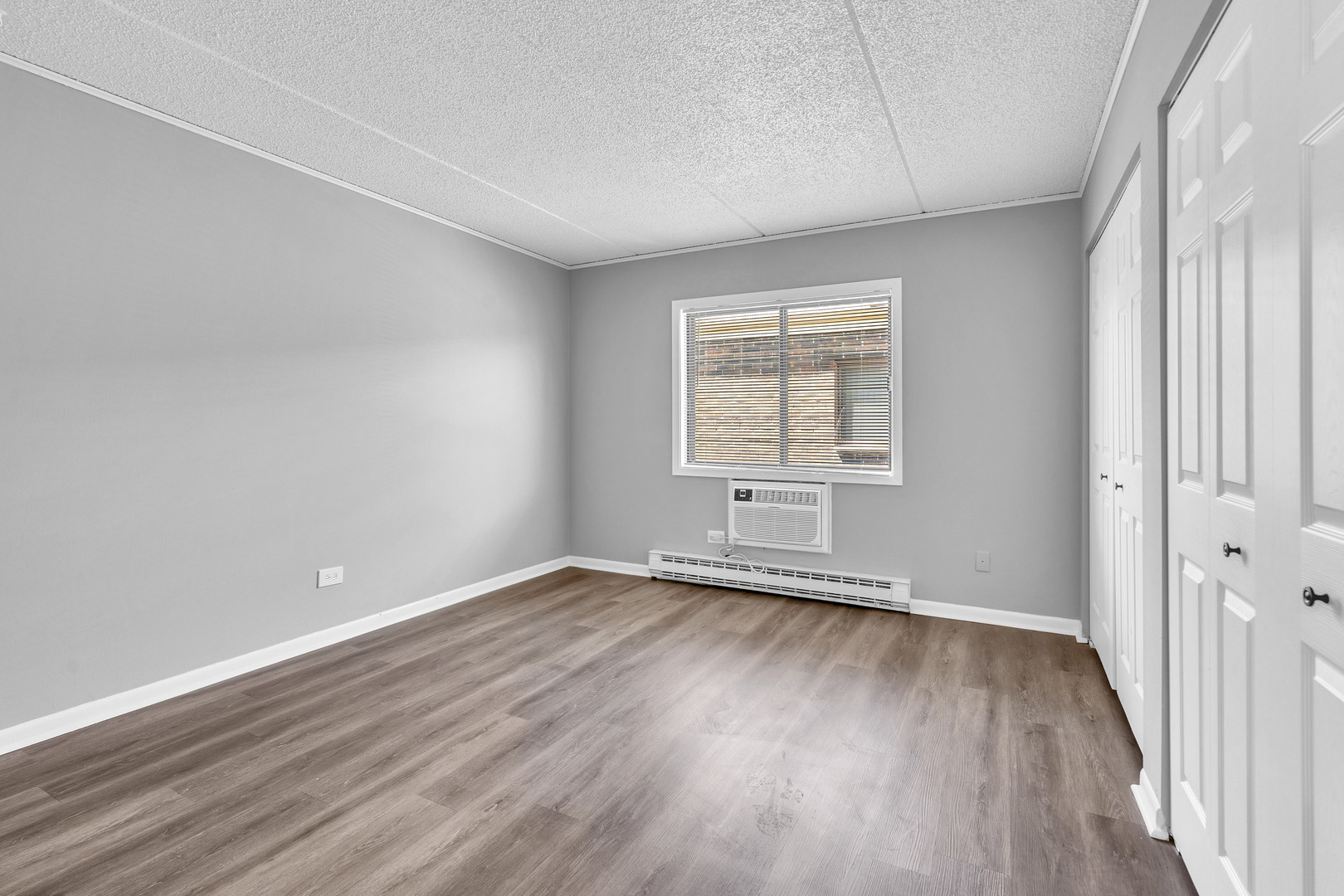942 North Rohlwing Road, Unit 201E Addison, IL 60101 - Photo 18 of 25 an empty room with wooden floor and windows
