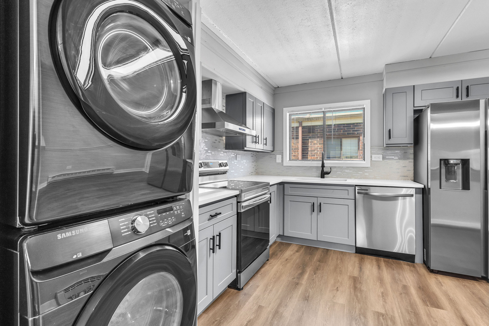 942 North Rohlwing Road, Unit 201E Addison, IL 60101 - Photo 10 of 25 a kitchen with stainless steel appliances granite countertop a sink a stove a washer and dryer