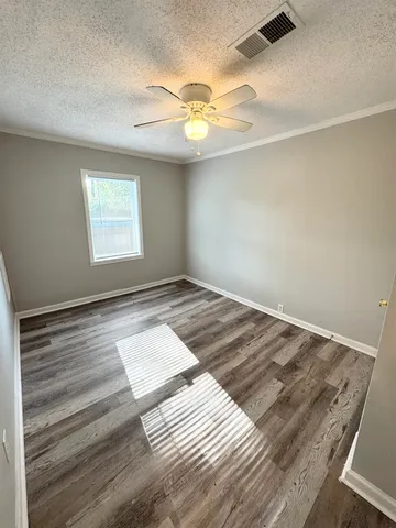 a view of a room with wooden floor and fan