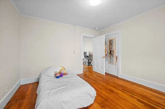 a room with a bed and a wooden floor