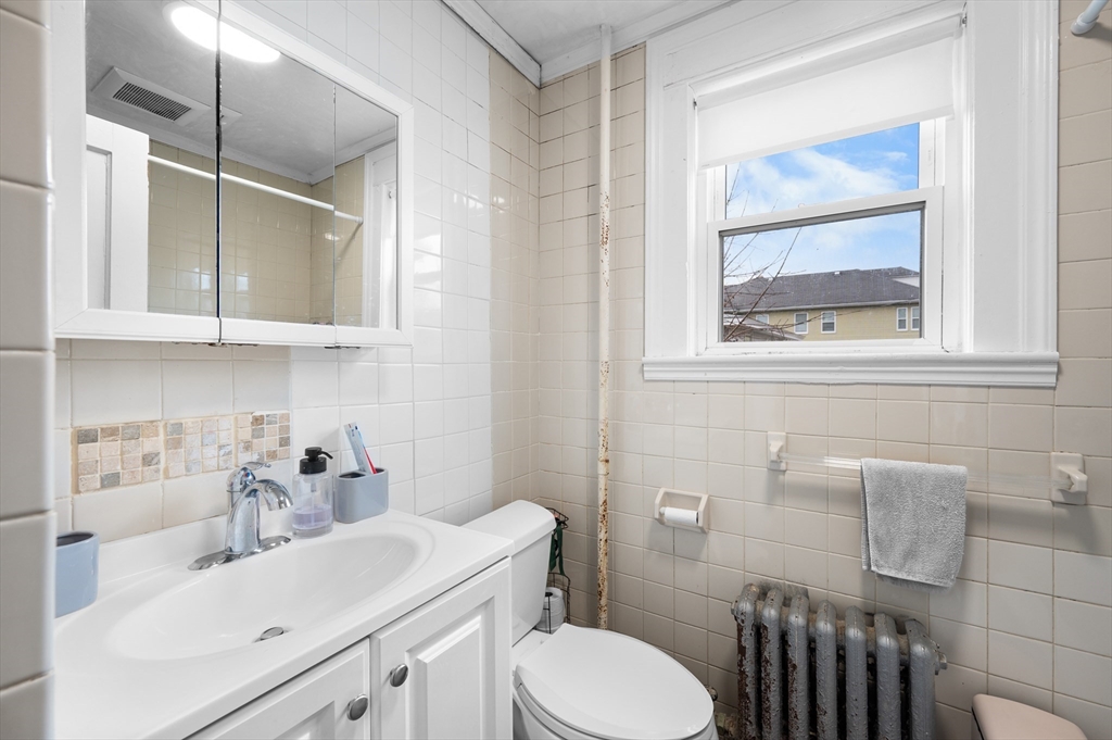 19 Oliver Street, Unit 2 Milford, MA 01757 - Photo 14 of 20 a bathroom with a sink a toilet and a mirror