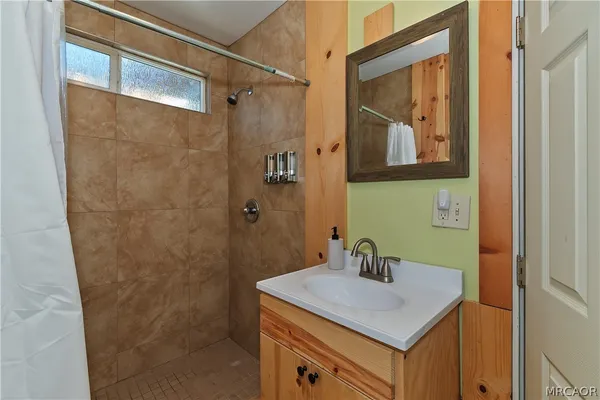 a bathroom with a granite countertop sink a mirror and a shower