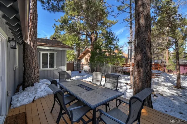 a view of a patio with table and chairs potted plants and large tree