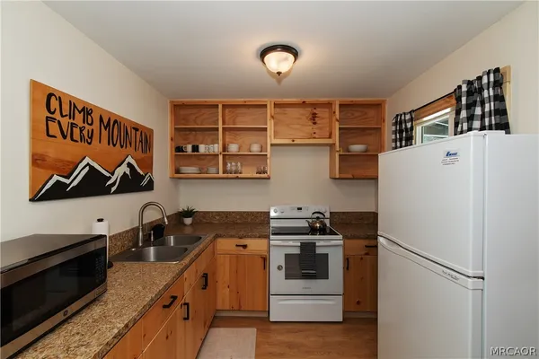 a kitchen with stainless steel appliances granite countertop a refrigerator and a stove