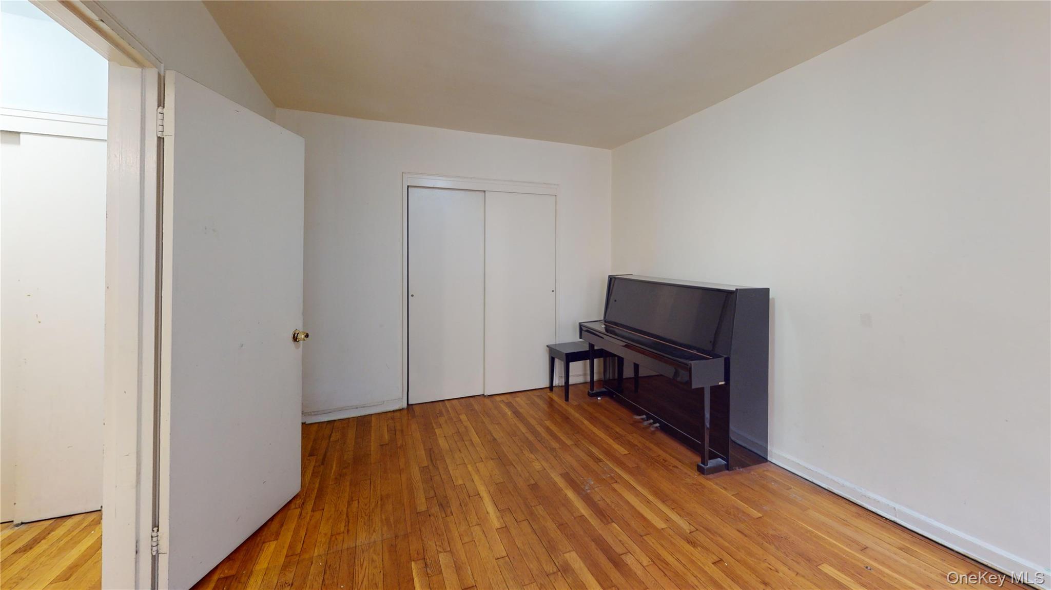 33-26 92nd Street, Unit 2T Queens, NY 11372 - Photo 7 of 10 a bedroom with a bed and wooden floor