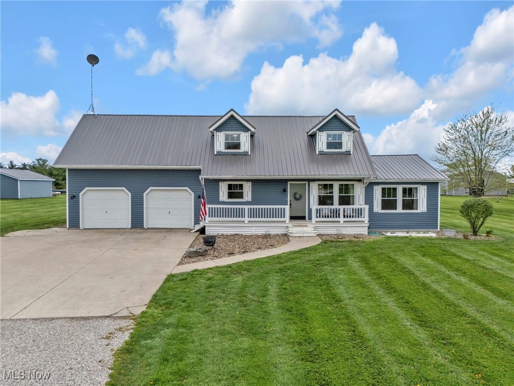 39233 Jones Road Litchfield, OH 44253 - Photo 1 of 46 View of front of house featuring a porch, a front yard, driveway, and an attached garage