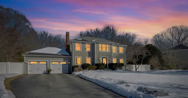 a front view of a house with a yard and parking
