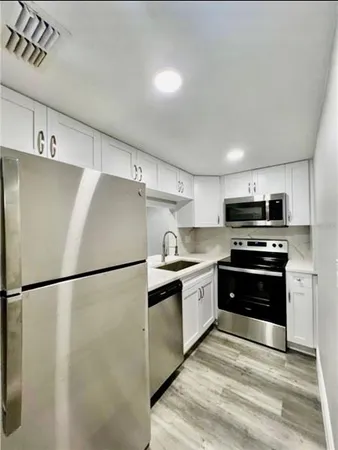 a kitchen with stainless steel appliances granite countertop a refrigerator stove a sink and a microwave